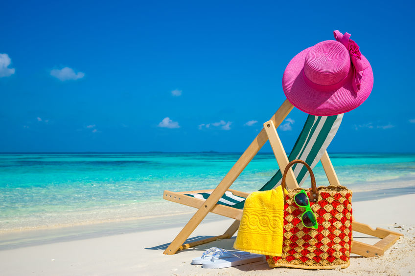 Beach chairs on the white sand beach with cloudy blue sky and su